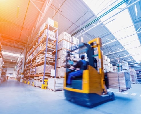 Image of a worker operating a forklift in a warehouse.