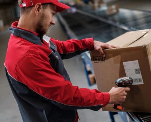 Image of a worker scanning a box in a warehouse.